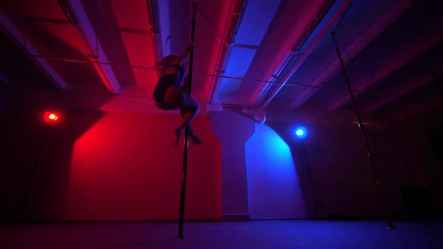 Adult sexy woman dancing dance in an intimate setting. Silhouette of a sexy woman dancing on red background. Pole dance from an old woman