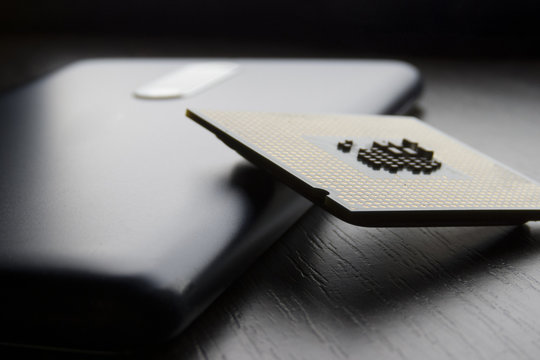 phone and processor chip lie on wooden table