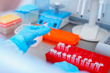 Dna test in the lab. a laboratory technician with a dispenser in his hands is conducting dna...