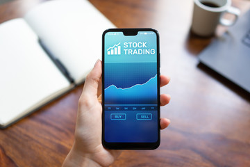 Mobile trading application with stock market chart on smartphone screen. Forex and investment...