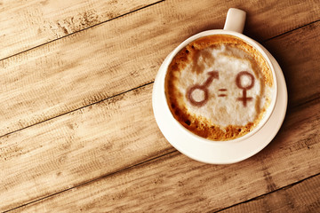 Symbol of gender equality on the coffee foam in wooden table