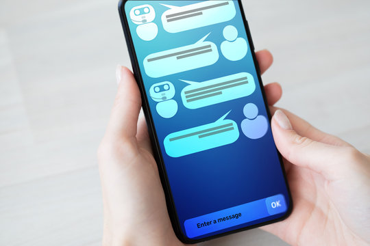 Customer and chatbot dialog on smartphone screen. AI. Artificial intelligence and service automation technology concept.