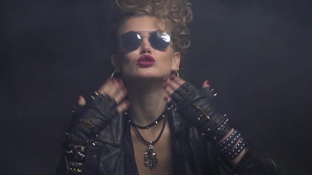 Surprised and flattered blonde rocker woman takes off her sunglasses