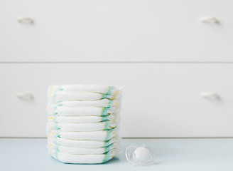 stack of diapers against a white wardrobe