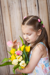 Little cute girl holding bouquet of tulips
