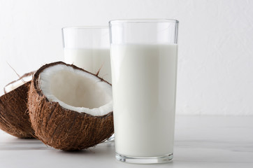 Closeup of homemade milk kefir,half of coconut on clean marble table