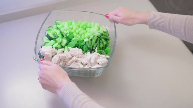 Close-up, slow motion, unrecognized female hand moves glass salad bowl. The concept of vegetarianism homemade diet and vegan