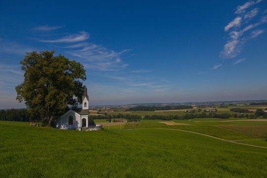 Scenic view over the Isental in Bavaria with a small chapell in the foreground