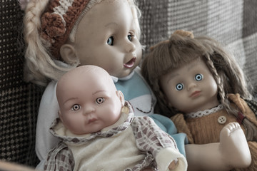 Creepy dolls. A mother with scary eyes sits with her children