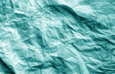 Crumpled sheet of paper in cyan color.