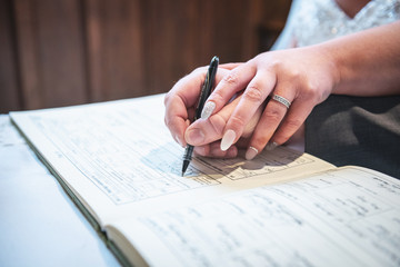 A bride and groom signing a dummy register 