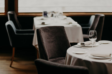 Table served for luxury dinner party with napkins, glasses and plates on white tableclothes. Nice decor. Wedding banquet. Cozy atmosphere in restaurant
