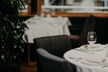 Served restaurant table with cutlery and wine glasses against blurred background. Banquet table for guests. Festive event. Cozy atmosphere. Catering cafe service