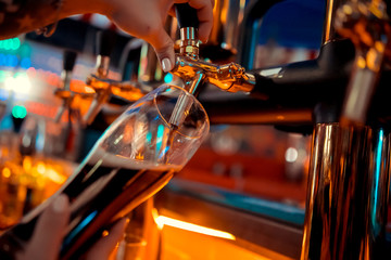 close-up of barman hand at beer tap pouring a draught lager beer