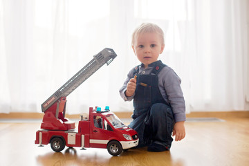 Little toddler boy, playing with fire truck car toy