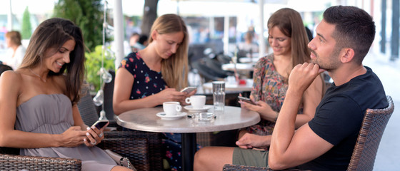 Three women addicted to their smartphones. They do not pay attention to their friend.