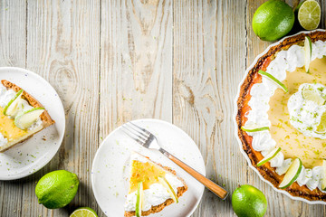 Homemade sweet cake, classic key lime pie with fresh limes, on wooden background copy space