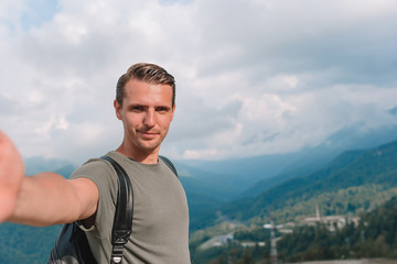 Fototapeta premium Man tourist taking selfie in mountains outdoors