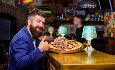 Hipster hungry eat italian pizza. Hipster client sit at bar counter. Man received delicious pizza. Enjoy your meal. Cheat meal concept. Pizza favorite restaurant food. Fresh hot pizza for dinner