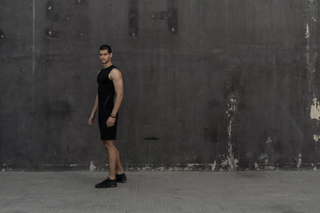 Sport model man posing gray wall background