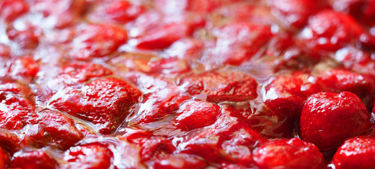 Red sweet strawberry jam background texture. Panoramic view, selective focus