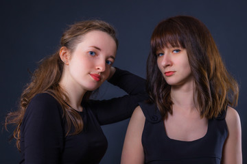 Group portrait of two girls on a dark background