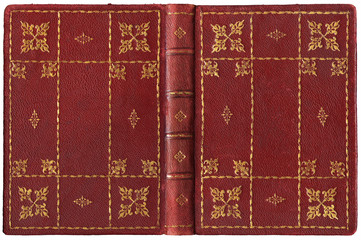 Antique open book in textured red leather cover with floral and abstract embossed golden decorations, isolated on white