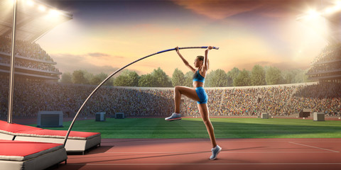 Young female pole vault athlete with pole bar. Women in sport clothes at athletic sport track in...