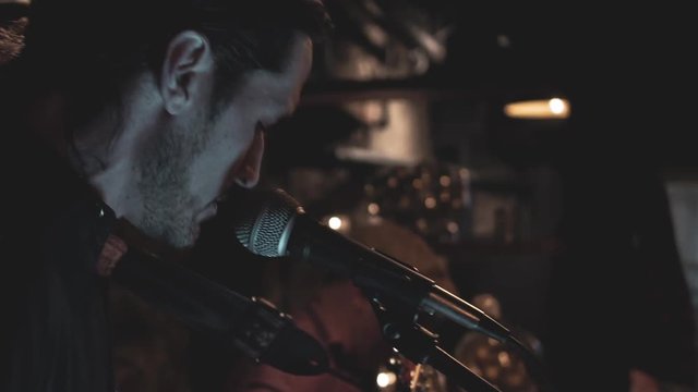 Man Playing Guitar and Singing at Night