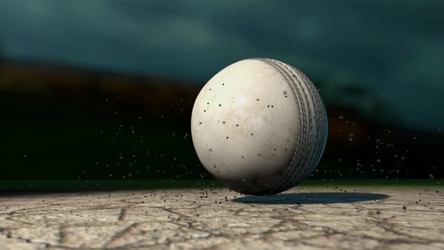 A ramped ultra motion close up of a white leather stitched cricket ball hitting a cracked cricket pitch with dirt particles emanating from the impact at night
