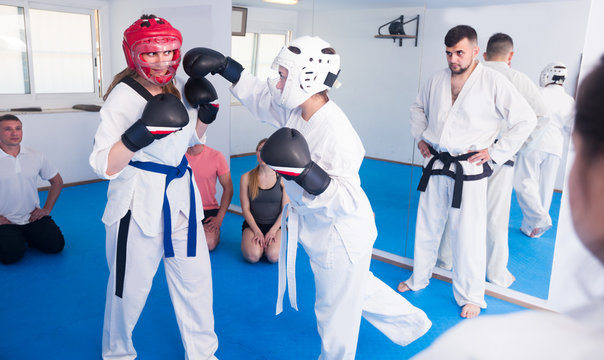Girls 20-26 years old are sparring in pair to use taekwondo technique