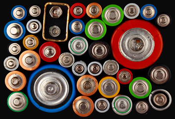 Old electric batteries on black background