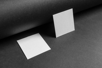 Mock-up of the two square business cards are on a black paper