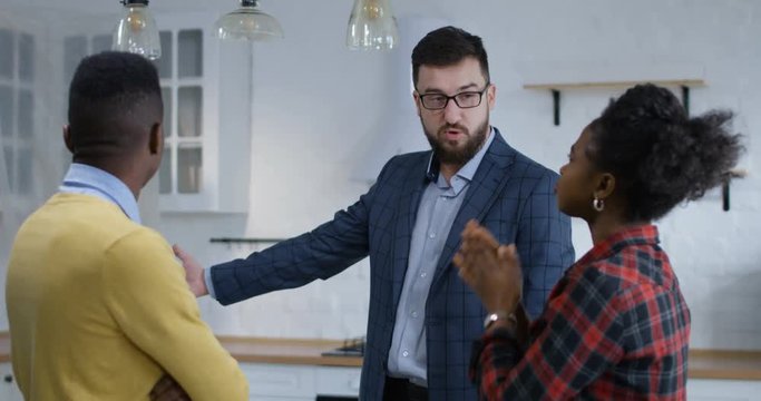 Medium shot of husband and wife checking new property with a real estate agent
