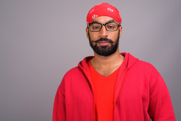 Portrait of young handsome Indian man wearing red shirt