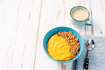 Top view of yellow smoothie bowl with granola