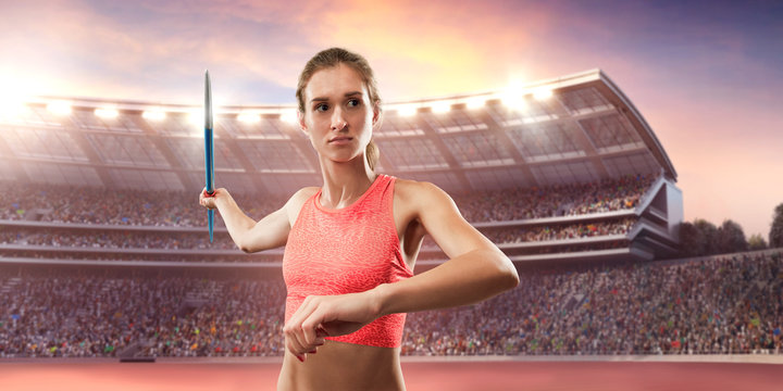 Young female javelin thrower throwing a spear. Athlete in sport clothes at athletic sport track in professional stadium
