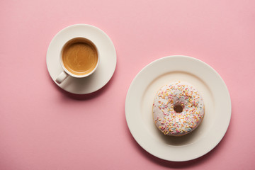 top view of sweet glazed doughnut near cup of coffee on pink background