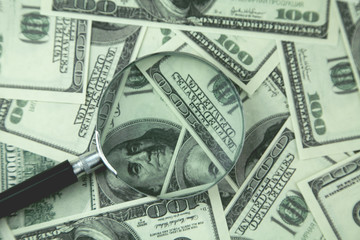 magnifying glass and money .