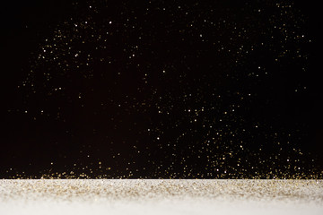 white table with bright shiny sparkles isolated on black