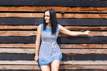 Obraz premium adult girl in a striped dress on wood background