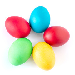 Multi-colored Easter eggs lie on a white background. Yellow, red, green and blue egg folded in the form of a flower.