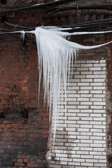 Huge icicles hanging from wires/wire break, fall icicles, dangerous situation, сold winter, poor thermal insulation, ice stalactite, formation of icicles, frost and winter weather concept.