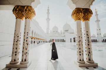 Traditionally dressed arabic woman wearing black burka visiting Sheikh Zayed Grand Mosque in Abu...