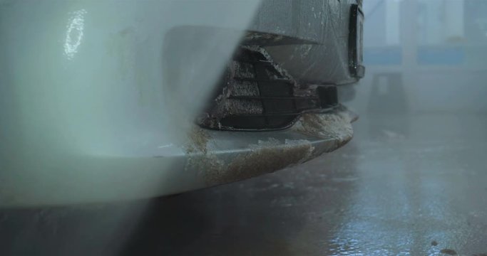 Professional guy (man) in a car wash washes a very dirty car using Karcher and splashes foam, wipes the car with a sponge. Concept of: Car wash, Wash accessories, Under high pressure.
