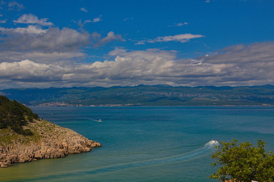 Scenic view from the island Krk towards the croatian mainland with clouds and a blue sky