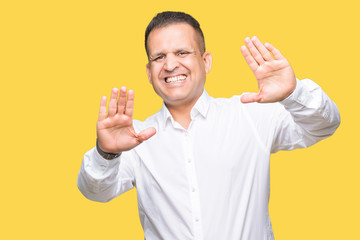 Middle age arab elegant man over isolated background Smiling doing frame using hands palms and fingers, camera perspective