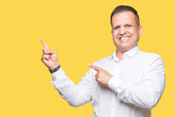 Middle age arab elegant man over isolated background smiling and looking at the camera pointing with two hands and fingers to the side.