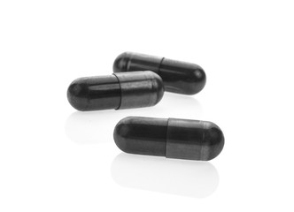 Charcoal capsules on white background.