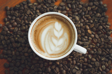 white coffee mug.  Coffee is a latte. table on the wooden table in vintage style, taken from the top view, see the froth of milk foam.